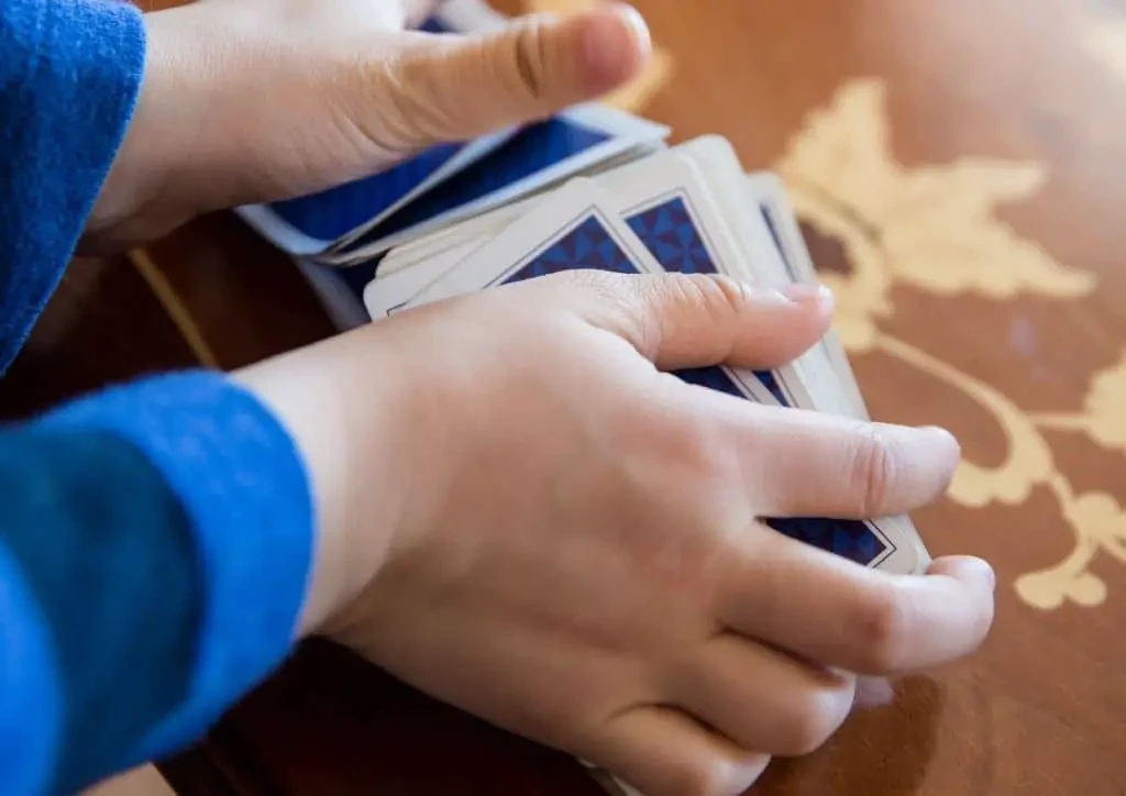Main d'enfant en train de mélanger un jeu de cartes