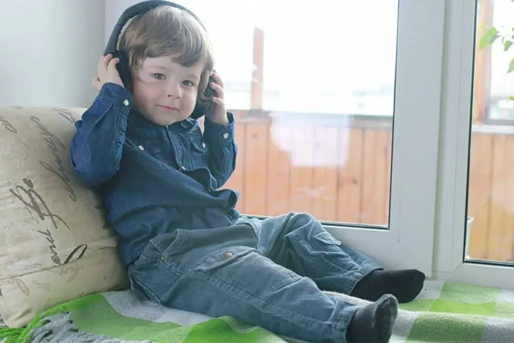 Jeune enfant équipé d'un casque sans fil pour profiter des histoires à écouter gratuitement