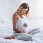 Femme enceinte regardant son ventre avec plaisir