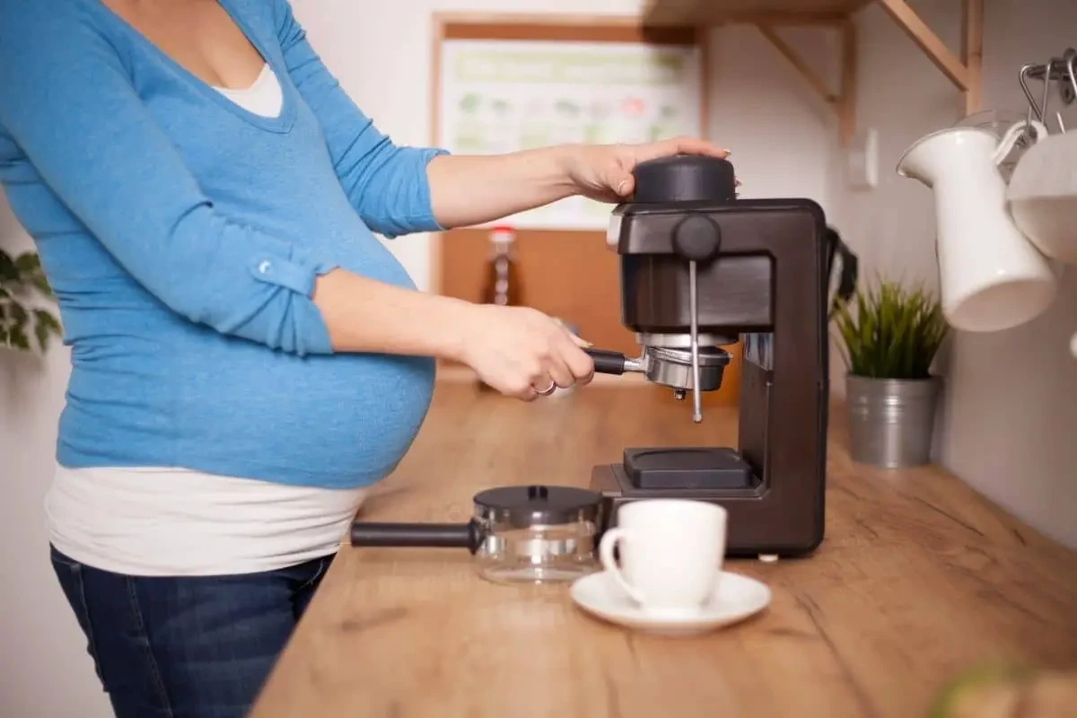 Femme enceinte préparant du café