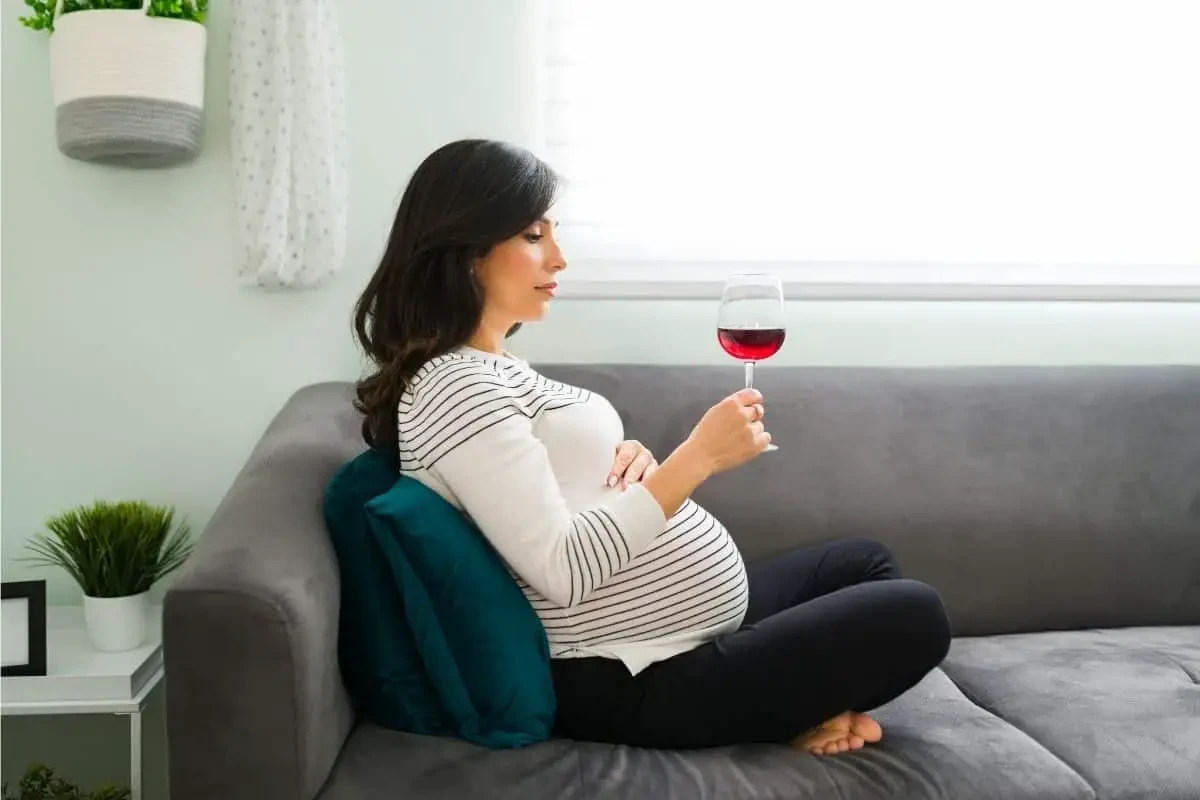 Femme buvant du vin rouge enceinte