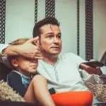 Père cachant un écran à son fils avec sa main