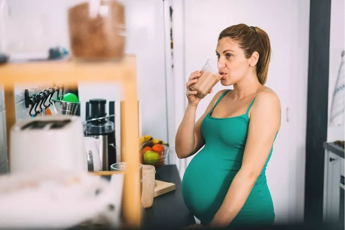 Femme enceinte en train de boire une boisson pendant sa grossesse