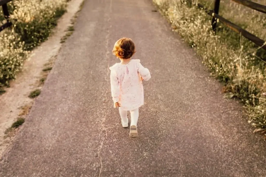 Petite fille portant une tunique marchant sur la route