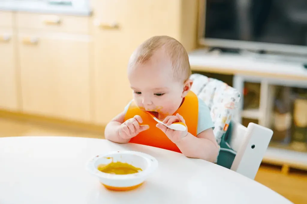 La tablette de la chaise haute qui se retire permet à bébé de manger à table